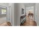 Inviting hallway with hardwood floors, white walls, and a view into the dining area, creating an open and airy feel at 348 Golf Vista Trl, Holly Springs, NC 27540