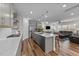 Open floor plan with modern kitchen, stainless steel appliances, and a center island at 348 Golf Vista Trl, Holly Springs, NC 27540
