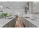 Modern kitchen with stainless steel appliances, quartz countertops, and an open floor plan at 348 Golf Vista Trl, Holly Springs, NC 27540