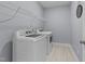 Modern laundry room includes sleek appliances, a wire shelf, and stylish flooring at 348 Golf Vista Trl, Holly Springs, NC 27540