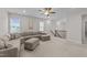 Spacious living area featuring a comfortable sectional sofa, ceiling fan, and natural light from the windows at 348 Golf Vista Trl, Holly Springs, NC 27540