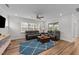 Bright living room featuring hardwood floors, comfortable seating, and plenty of natural light from large windows at 348 Golf Vista Trl, Holly Springs, NC 27540