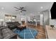 Open-concept living area with hardwood floors, a ceiling fan, comfortable seating, and seamless flow to kitchen and dining at 348 Golf Vista Trl, Holly Springs, NC 27540