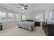 Spacious main bedroom with a tray ceiling, carpet flooring, and natural light at 348 Golf Vista Trl, Holly Springs, NC 27540