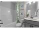 Neutral bathroom featuring a tub, toilet, gray vanity, and decorative floral artwork at 3625 Bailey Lake Dr, Fuquay Varina, NC 27526