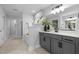 Bright bathroom featuring gray cabinets, double sinks, a soaking tub, and modern design at 3625 Bailey Lake Dr, Fuquay Varina, NC 27526