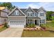 Inviting two-story home showcasing a two-car garage, gray siding, manicured landscaping, and a charming front porch at 3625 Bailey Lake Dr, Fuquay Varina, NC 27526