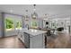 Open-concept kitchen with an island and barstool seating flowing into the dining and living areas at 3625 Bailey Lake Dr, Fuquay Varina, NC 27526