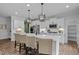 Bright kitchen with white cabinetry, island with seating, and modern pendant lighting at 3625 Bailey Lake Dr, Fuquay Varina, NC 27526