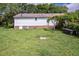 Exterior of the house with a grassy backyard, trellises, and patio at 3627 Nc 57, Hillsborough, NC 27278
