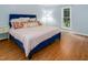 Bright bedroom featuring a blue bedframe, wood floors, and natural light from the window at 3627 Nc 57, Hillsborough, NC 27278