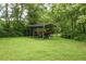 Spacious carport shelter with lawn equipment and a trailer, set on a grassy lawn at 3627 Nc 57, Hillsborough, NC 27278