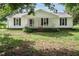 Inviting single-story home featuring a classic white facade, dark shutters, and a cozy front porch at 3627 Nc 57, Hillsborough, NC 27278