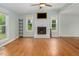 Open living room with beautiful wood floors, fireplace, ceiling fan and lots of natural light at 3627 Nc 57, Hillsborough, NC 27278