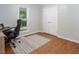 An office space with a rolling desk chair, wood floors, and natural light from the window at 3627 Nc 57, Hillsborough, NC 27278