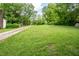 Expansive grassy yard with a long driveway and lush greenery; surrounded by mature trees at 3627 Nc 57, Hillsborough, NC 27278
