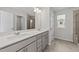 Modern bathroom with dual sinks, gray cabinets, stylish lighting, and a view of the tiled shower at 380 Garden Vine Trl, Raleigh, NC 27610