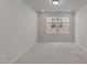 A carpeted bedroom with ample natural light coming in from the two windows at 380 Garden Vine Trl, Raleigh, NC 27610