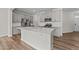 Bright kitchen featuring quartz countertops, stainless appliances, and a large island at 380 Garden Vine Trl, Raleigh, NC 27610
