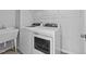 Bright laundry area with white appliances, a utility sink, and overhead storage at 380 Garden Vine Trl, Raleigh, NC 27610