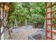 Landscaped backyard with raised garden beds, pebble ground covering, string lights, and mature trees at 3829 Westbury Lake Dr, Raleigh, NC 27603