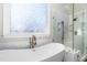 Serene bathroom with a freestanding tub, frameless shower, and a decorative window at 3829 Westbury Lake Dr, Raleigh, NC 27603
