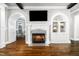 Cozy fireplace flanked by built-in shelving, arched entryway, and hardwood floors at 3829 Westbury Lake Dr, Raleigh, NC 27603