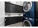 Practical laundry room with dark cabinetry, ample counter space, and stacked washer/dryer units at 3829 Westbury Lake Dr, Raleigh, NC 27603