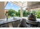 Outdoor kitchen with stainless steel appliances, marble countertop, and a view of the pool at 3829 Westbury Lake Dr, Raleigh, NC 27603