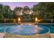 Outdoor pool with spa features nearby fire pits and lush greenery, providing a luxurious private escape at 3829 Westbury Lake Dr, Raleigh, NC 27603