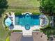 Aerial view of a backyard pool with a slide, spa, and manicured landscaping at 3829 Westbury Lake Dr, Raleigh, NC 27603