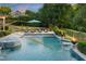 Outdoor pool with jacuzzi features water fountains, nearby fire pits, and an umbrella-covered lounge area with seating at 3829 Westbury Lake Dr, Raleigh, NC 27603