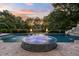 Outdoor pool with spa features water fountains, nearby fire pits, and a beautiful blue sky for a luxurious escape at 3829 Westbury Lake Dr, Raleigh, NC 27603
