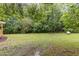 Large backyard with lush green grass and plenty of trees, looking out into the woods at 4420 W River Rd, Franklinton, NC 27525