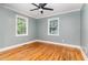 Comfortable bedroom with hardwood floors, two large windows, gray walls, and white trim at 4420 W River Rd, Franklinton, NC 27525