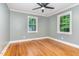 Bright bedroom boasts hardwood floors, a ceiling fan, neutral paint, and two windows at 4420 W River Rd, Franklinton, NC 27525