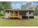View of the home's back exterior with wooden deck, back door, and siding at 4420 W River Rd, Franklinton, NC 27525