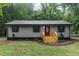 Charming single-story home with a gray exterior, a red front door, and a freshly stained natural wood porch and steps at 4420 W River Rd, Franklinton, NC 27525