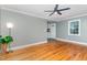 Bright living room with hardwood floors, gray walls, white trim and a modern ceiling fan at 4420 W River Rd, Franklinton, NC 27525