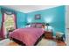 Comfortable bedroom with blue walls with view of green trees from the window at 4953 Tuckahoe Trce, Wake Forest, NC 27587