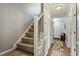 Hallway with staircase featuring carpeted steps and white railings plus hardwood floors at 4953 Tuckahoe Trce, Wake Forest, NC 27587