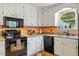 Functional kitchen with white cabinets, modern appliances, and a bright window view at 4953 Tuckahoe Trce, Wake Forest, NC 27587