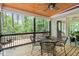 Covered porch with wood ceiling featuring table with metal chairs with scenic wooded view at 4953 Tuckahoe Trce, Wake Forest, NC 27587