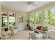 Bright sunroom with tile floor featuring white wicker seating and lots of natural light at 4953 Tuckahoe Trce, Wake Forest, NC 27587