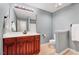 Well-lit bathroom featuring a cherry wood vanity, large mirror, and light blue walls, offering a clean and functional space at 5045 Homeplace Dr, Apex, NC 27539