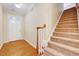 Spacious entryway with hardwood floors, a staircase with carpeted steps and a white front door at 5045 Homeplace Dr, Apex, NC 27539
