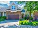 Charming brick and siding townhome featuring an attached two-car garage and well-maintained landscaping at 5045 Homeplace Dr, Apex, NC 27539