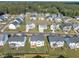 A high-angle aerial of a neighborhood with green spaces, fenced yards, and well-maintained homes at 508 White Oak Branch Ln, Apex, NC 27523