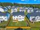 Stunning aerial view of a neighborhood featuring well-maintained homes, green lawns, and mature trees against a clear blue sky at 508 White Oak Branch Ln, Apex, NC 27523