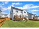 View of a two-story home's backyard with a wooden deck, a fenced-in yard, and lush green grass at 508 White Oak Branch Ln, Apex, NC 27523